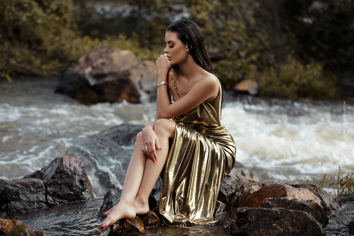 lanvin-videos-designer-fashion-brand-woman-in-golden-luxury-dress-sitting-on-a-rock-at-a-river